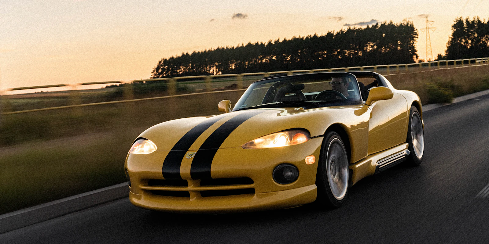 Yellow Dodge Viper with black racing stripes on the road